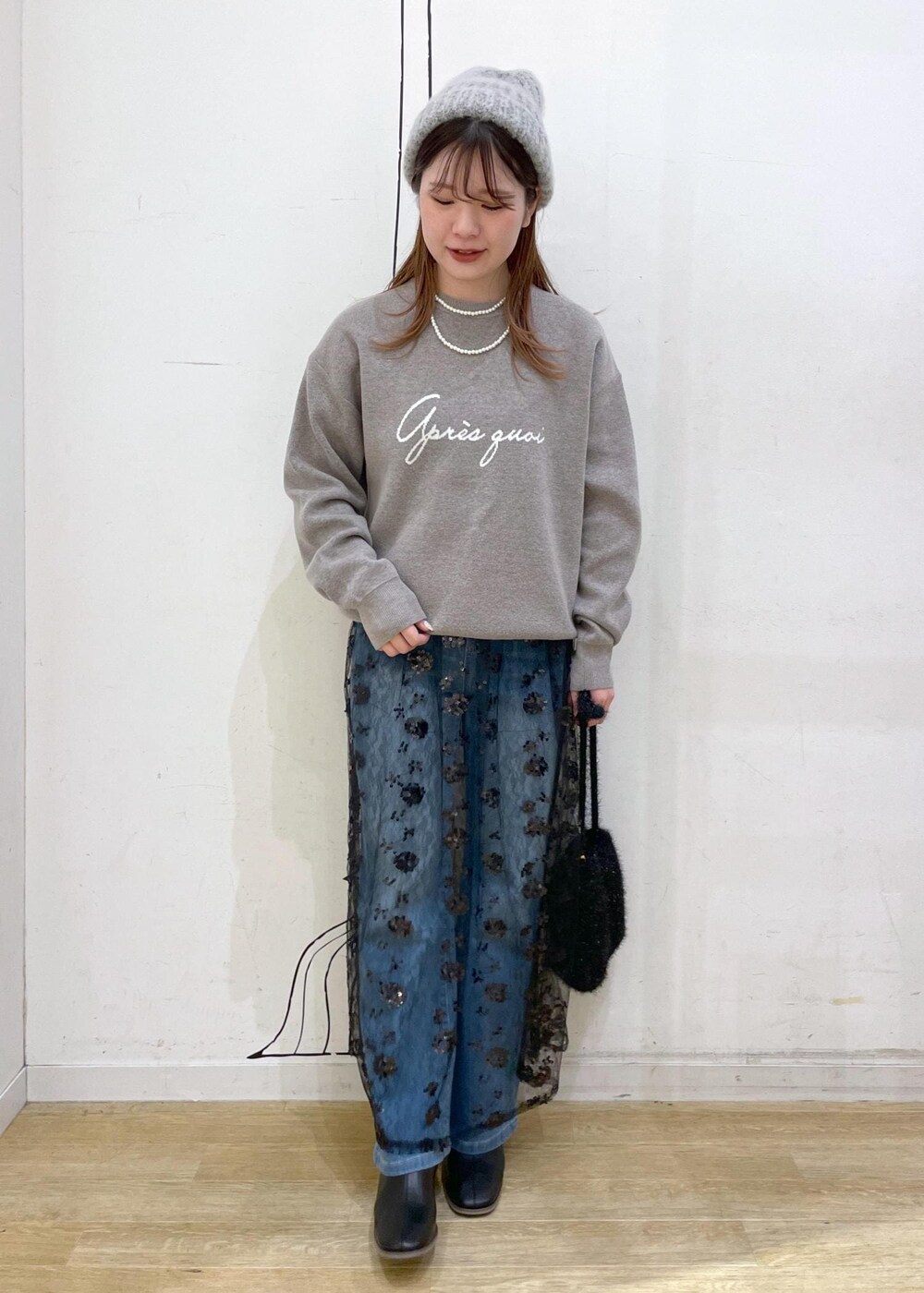 ブラック系のスカート、グレー系のニット/セーター、ブラック系のブーツを着用したレディースの秋コーディネートの4枚目の写真