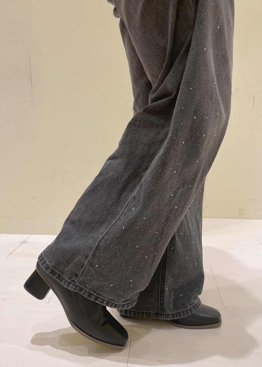 ホワイト系のタンクトップ、グレー系のベスト、ブラック系のブーツを着用したレディースの秋コーディネートの10枚目の写真