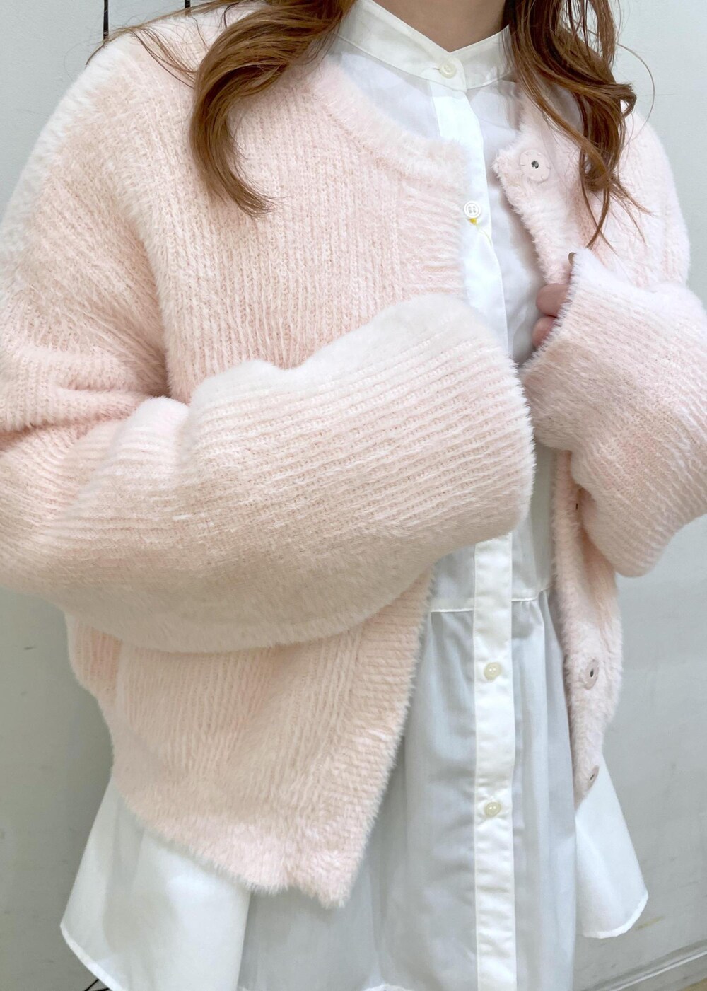 ブルー系のデニムパンツ、ホワイト系のショルダーバッグ、ホワイト系のパンプスを着用したレディースの冬コーディネートの5枚目の写真