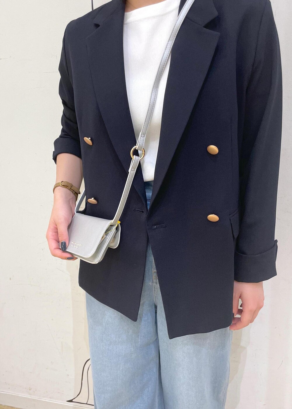 ブルー系のデニムパンツ、シルバー系のサンダル、ホワイト系のニット/セーターを着用したレディースの夏コーディネートの7枚目の写真