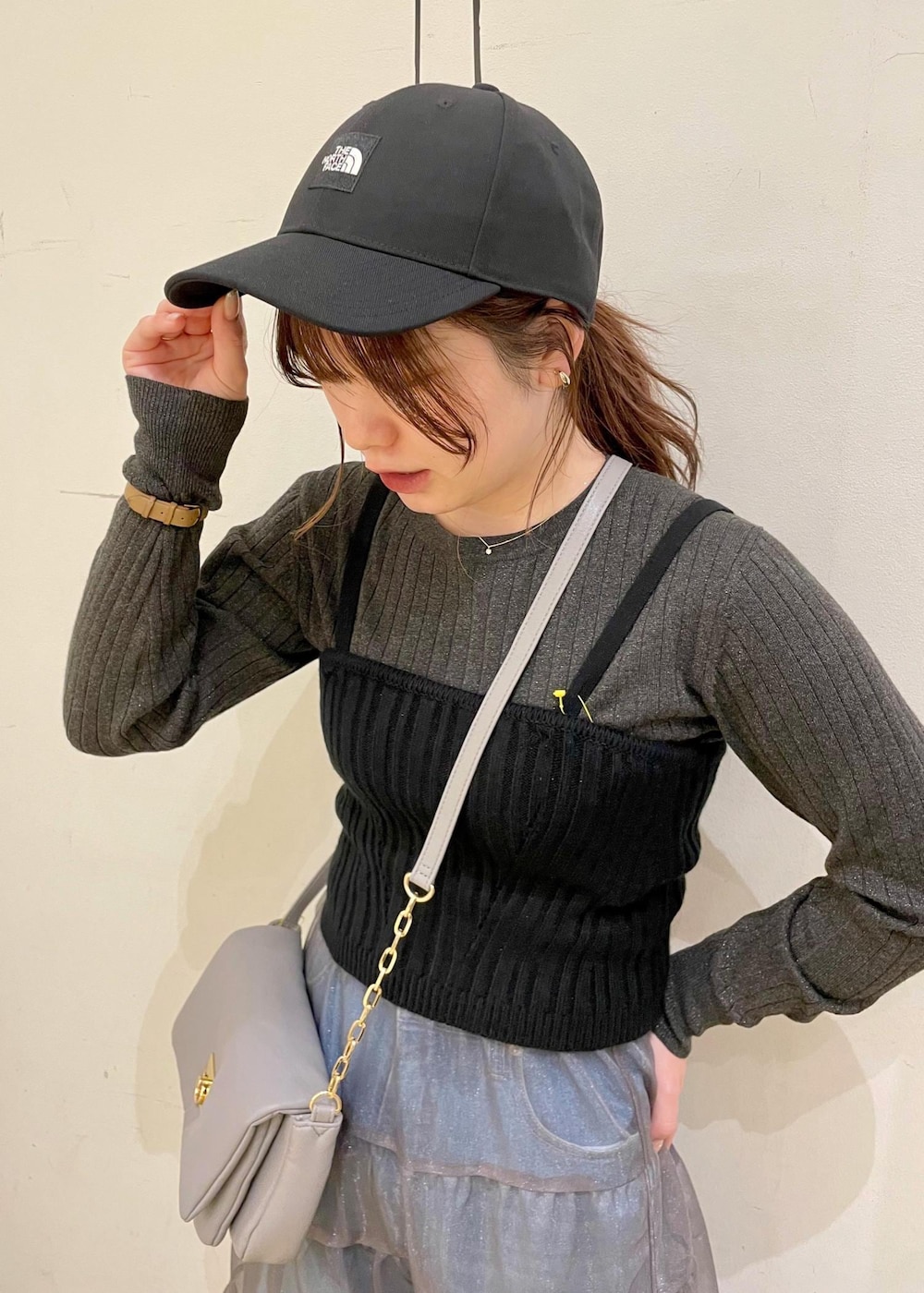 グレー系のショルダーバッグ、ブラック系のベスト、グレー系のニット/セーターを着用したレディースの春コーディネートの8枚目の写真