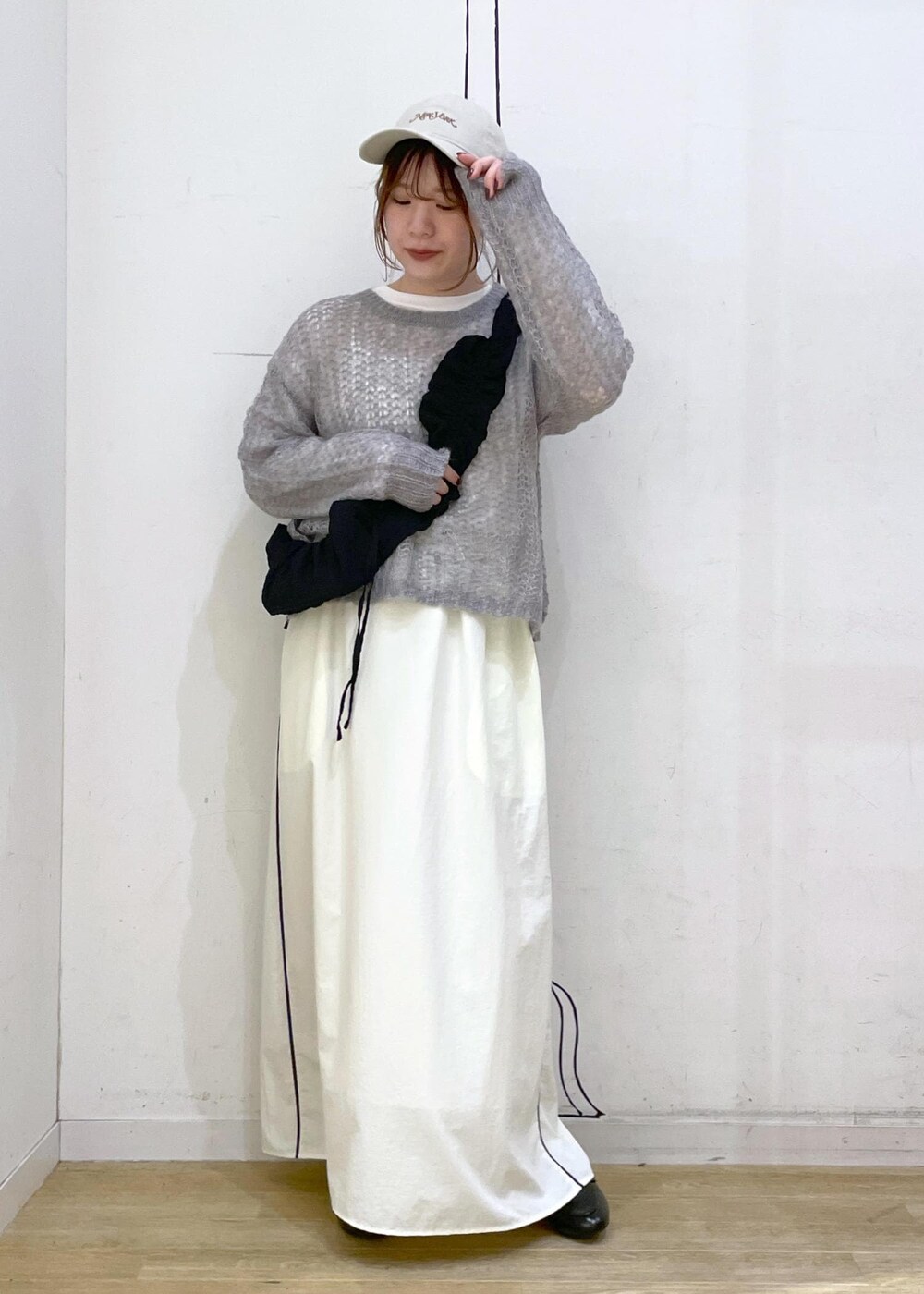 ブラック系のローファー、ホワイト系のスカート、グレー系のニット/セーターを着用したレディースの秋コーディネートの10枚目の写真