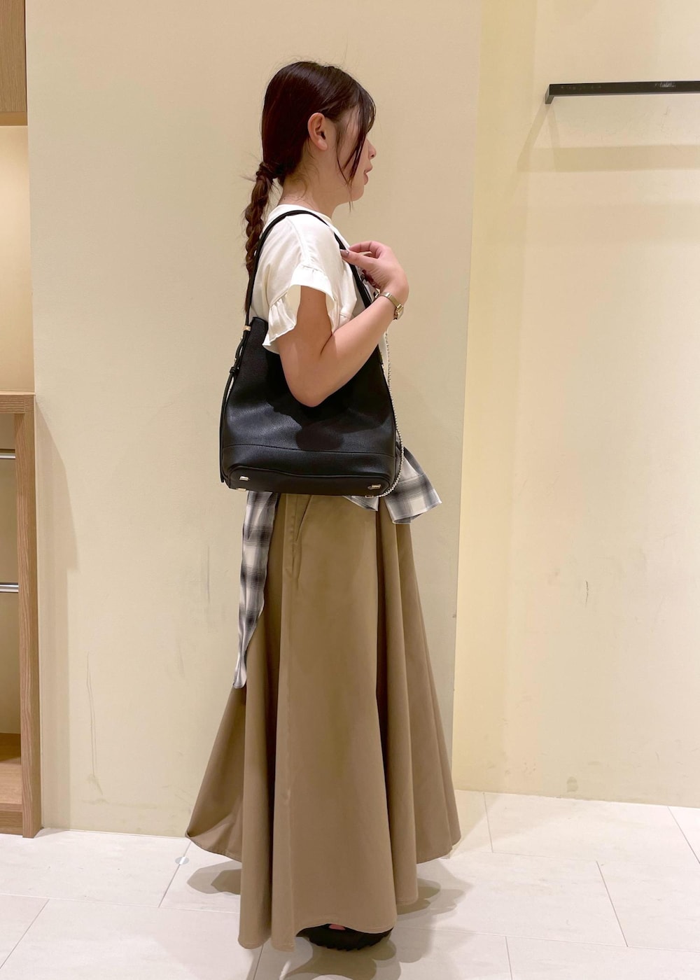 ブラック系のサンダル、ベージュ系のスカート、ホワイト系のシャツ/ブラウスを着用したレディースの夏コーディネートの3枚目の写真