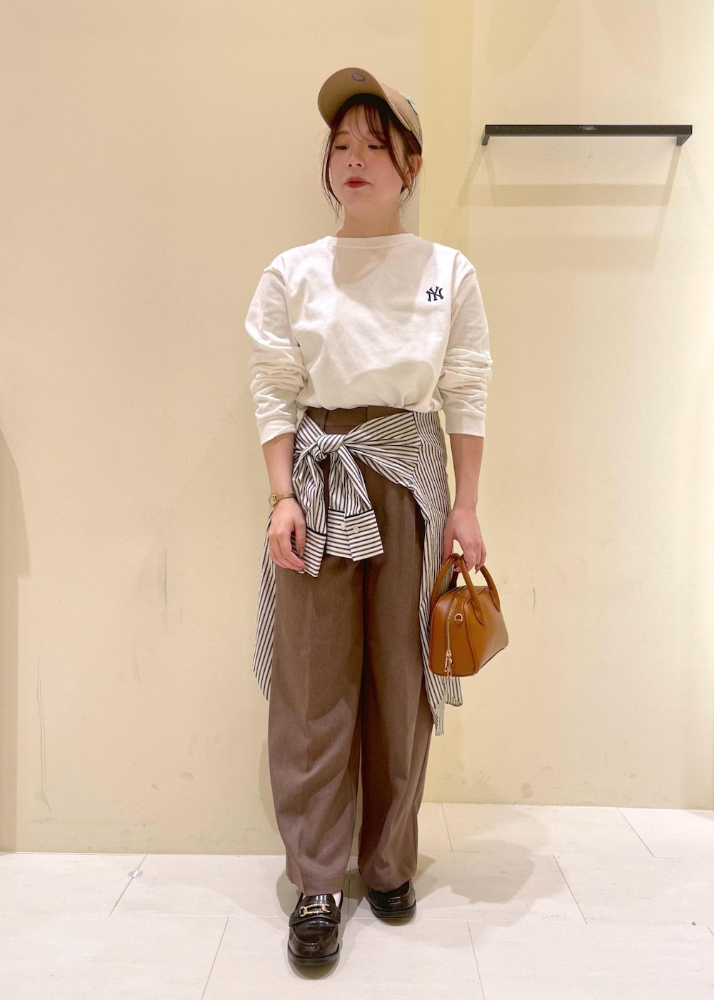 ホワイト系のシャツ/ブラウス、ホワイト系のTシャツ/カットソー、ベージュ系のスラックスを着用したレディースの秋コーディネートの5枚目の写真