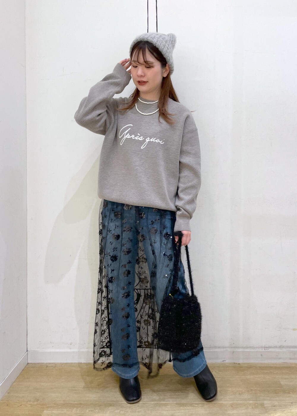 ブラック系のスカート、グレー系のニット/セーター、ブラック系のブーツを着用したレディースの秋コーディネートの10枚目の写真