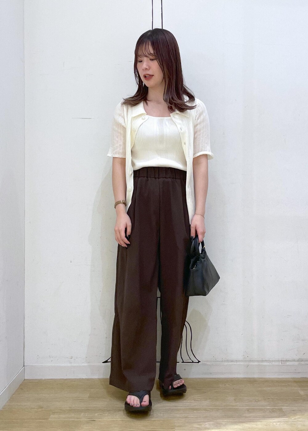 ブラック系のサンダル、ホワイト系のキャミソール、ブラック系のショルダーバッグを着用したレディースの夏コーディネートの4枚目の写真