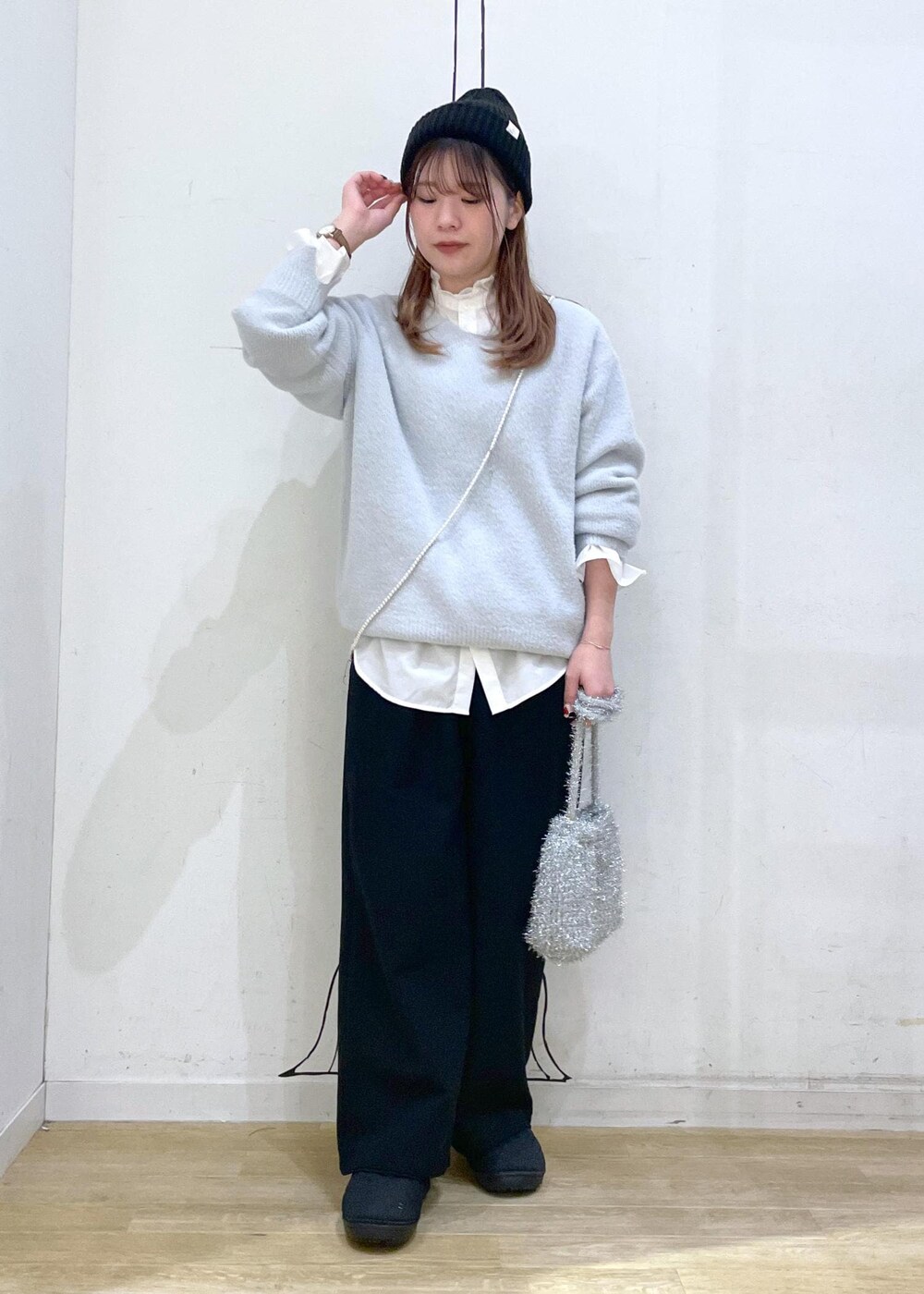 ベージュ系のダウンジャケット/コート、シルバー系のショルダーバッグ、ブルー系のニット/セーターを着用したレディースの冬コーディネートの9枚目の写真