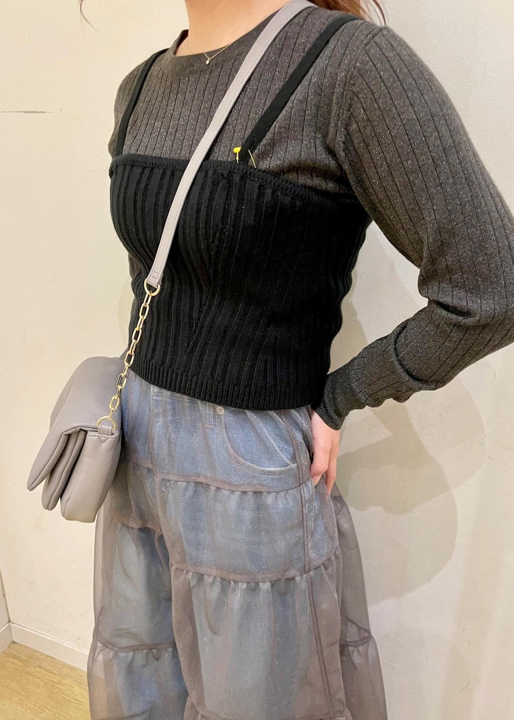グレー系のショルダーバッグ、ブラック系のベスト、グレー系のニット/セーターを着用したレディースの春コーディネートの4枚目の写真