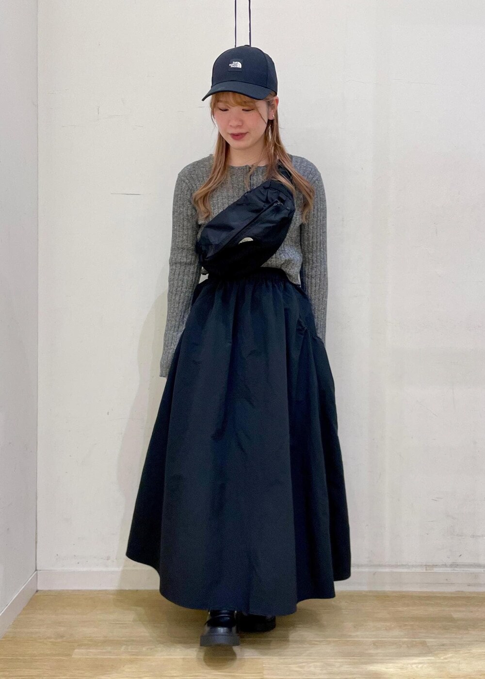 ブラック系のスカート、ブラック系のローファー、ブラック系のニット/セーターを着用したレディースの春コーディネートの9枚目の写真