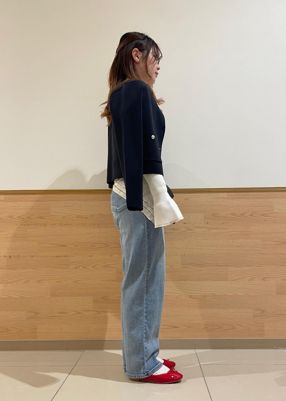 ブルー系のカーディガン/ボレロ、ホワイト系のニット/セーター、ブラック系のハンドバッグを着用したレディースの春コーディネートの3枚目の写真