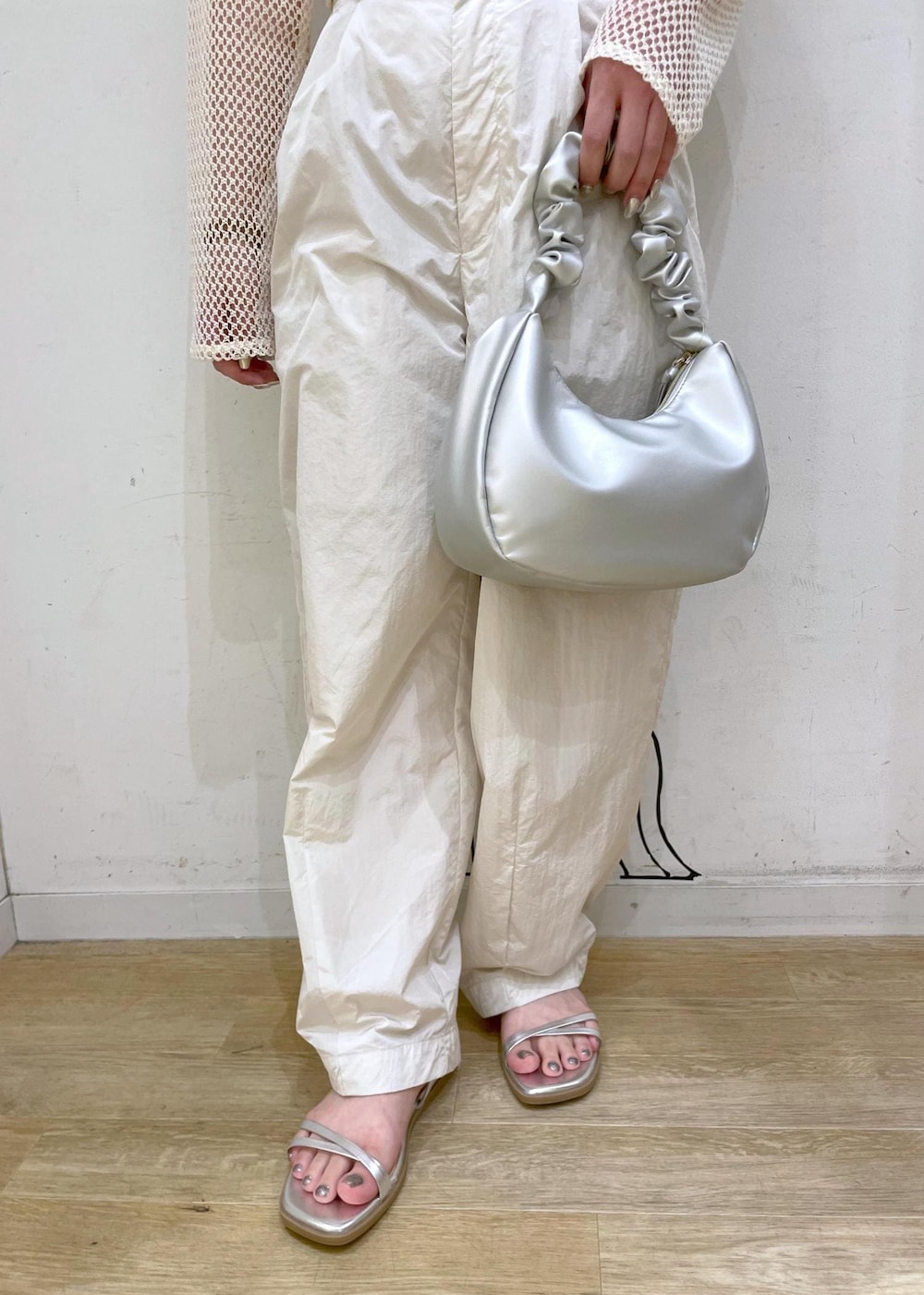 シルバー系のサンダル、シルバー系のハンドバッグ、ホワイト系のその他パンツを着用したレディースの夏コーディネートの6枚目の写真