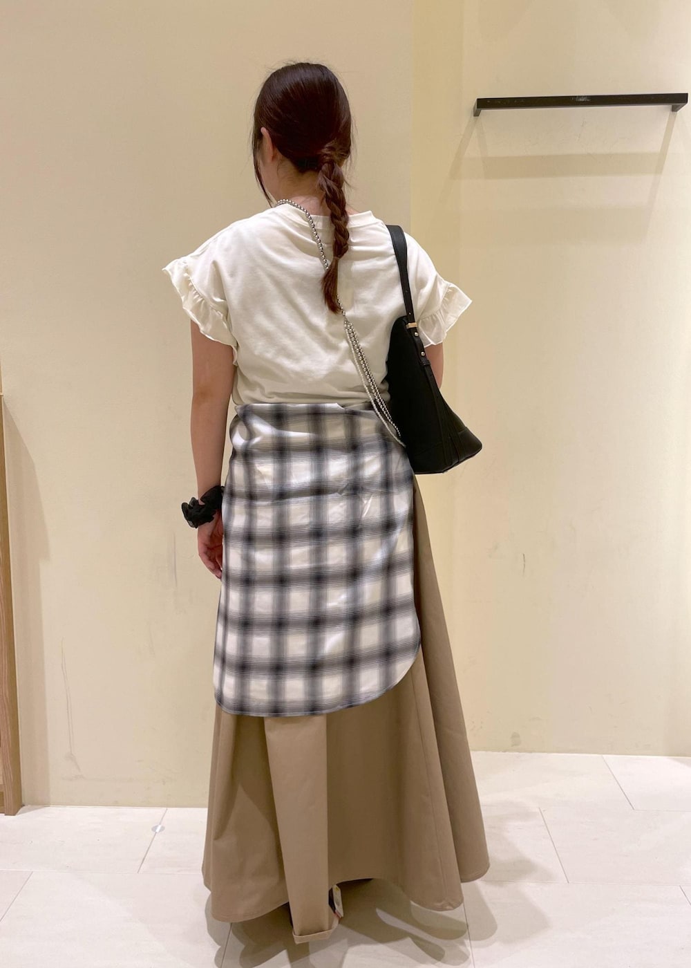 ブラック系のサンダル、ベージュ系のスカート、ホワイト系のシャツ/ブラウスを着用したレディースの夏コーディネートの2枚目の写真