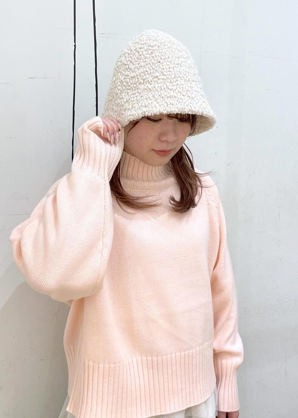 ピンク系のニット/セーター、ブラック系のブーツ、ブラック系のショルダーバッグを着用したレディースの冬コーディネートの9枚目の写真