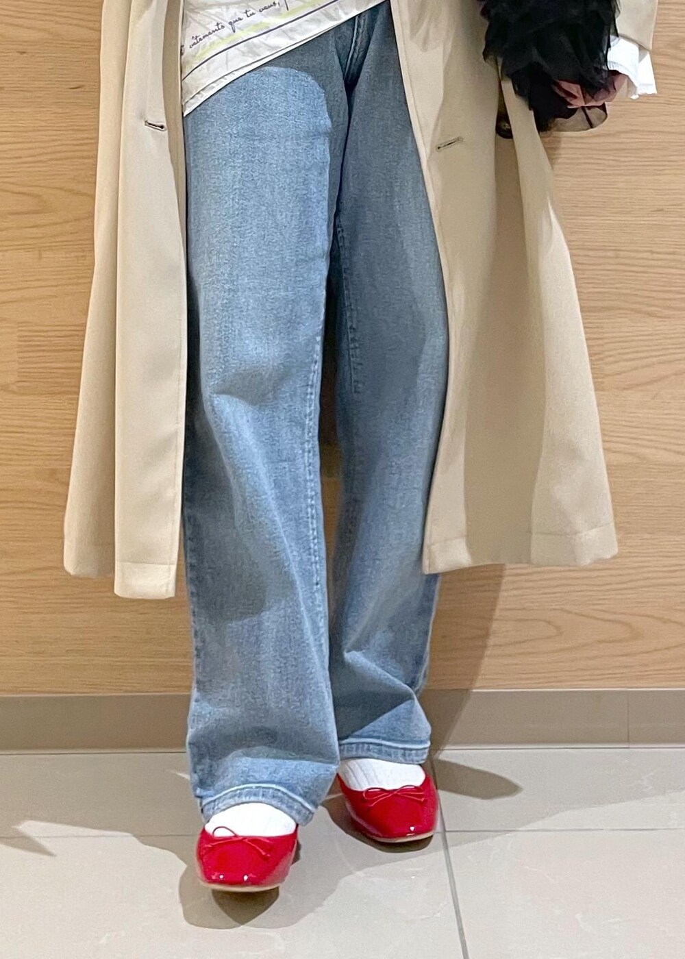 ブルー系のベスト、ホワイト系のニット/セーター、ベージュ系のトレンチコートを着用したレディースの春コーディネートの8枚目の写真