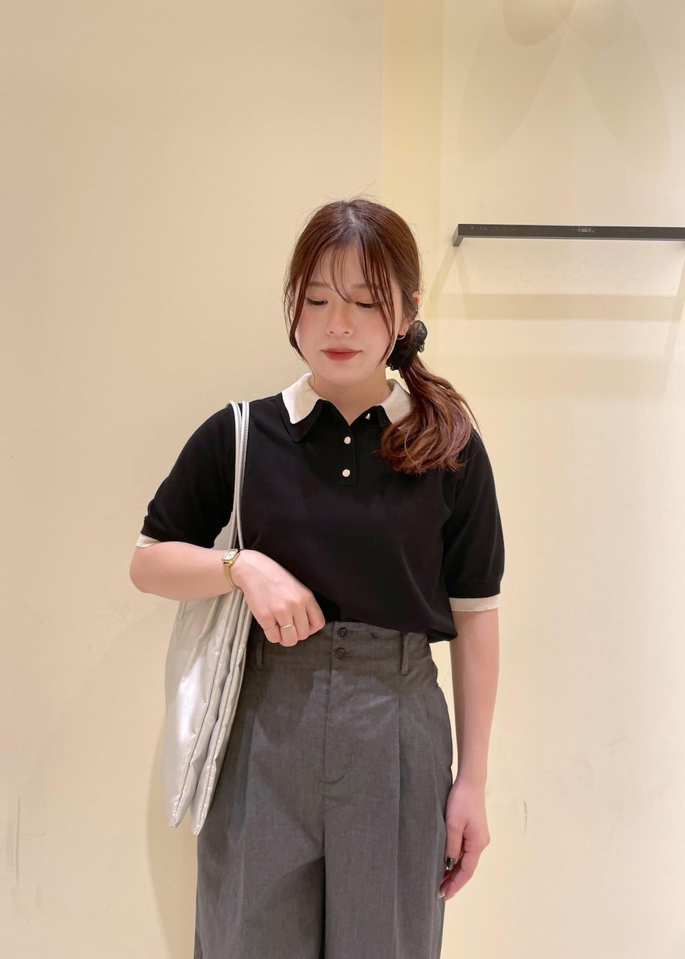 シルバー系のトートバッグ、ブラウン系のサンダル、ブラック系のポロシャツを着用したレディースの夏コーディネートの10枚目の写真