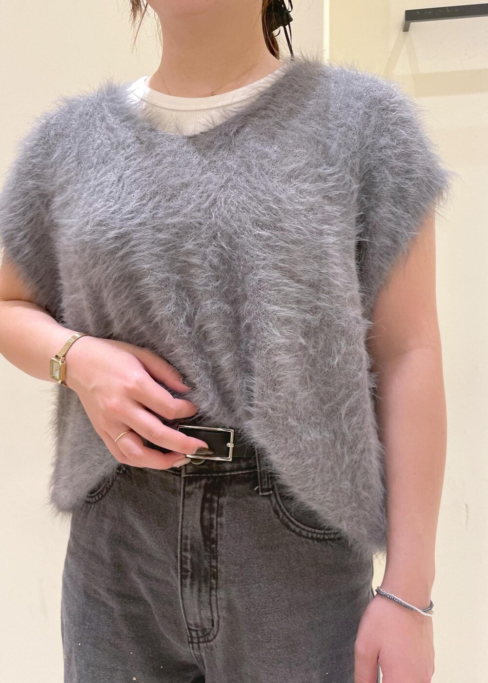 ホワイト系のタンクトップ、グレー系のベスト、ブラック系のブーツを着用したレディースの秋コーディネートの6枚目の写真