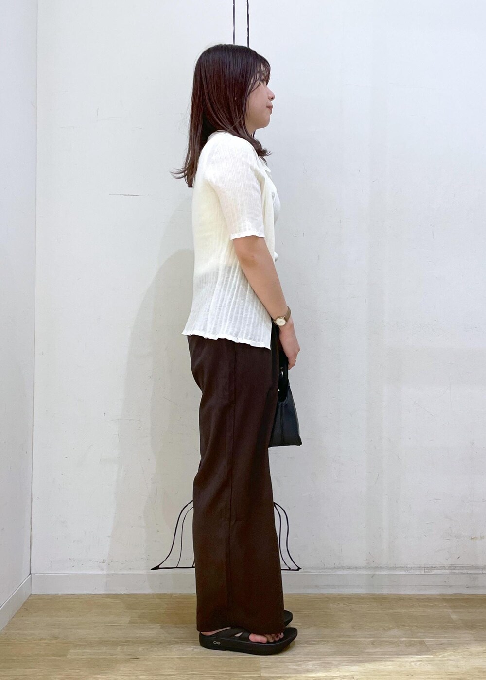 ブラック系のサンダル、ホワイト系のキャミソール、ブラック系のショルダーバッグを着用したレディースの夏コーディネートの3枚目の写真