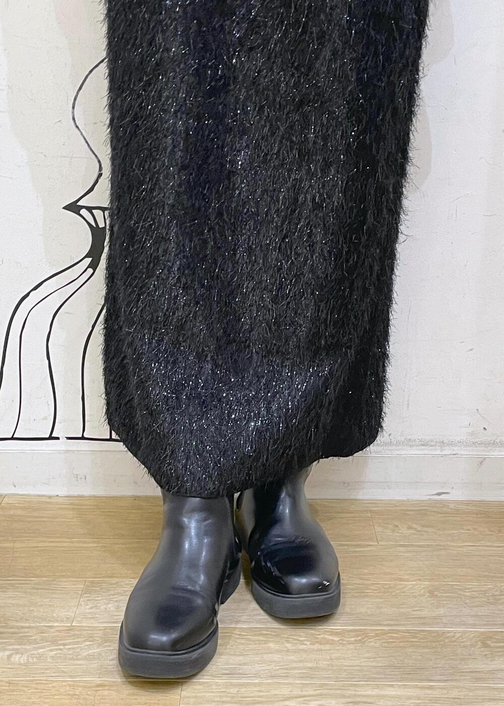 ブラック系のスカート、ベージュ系のニット/セーター、ブラック系のブーツを着用したレディースの冬コーディネートの8枚目の写真