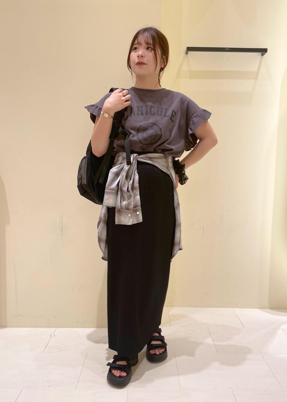 ブラック系のスカート、ブラック系のサンダル、グレー系のTシャツ/カットソーを着用したレディースの夏コーディネートの4枚目の写真