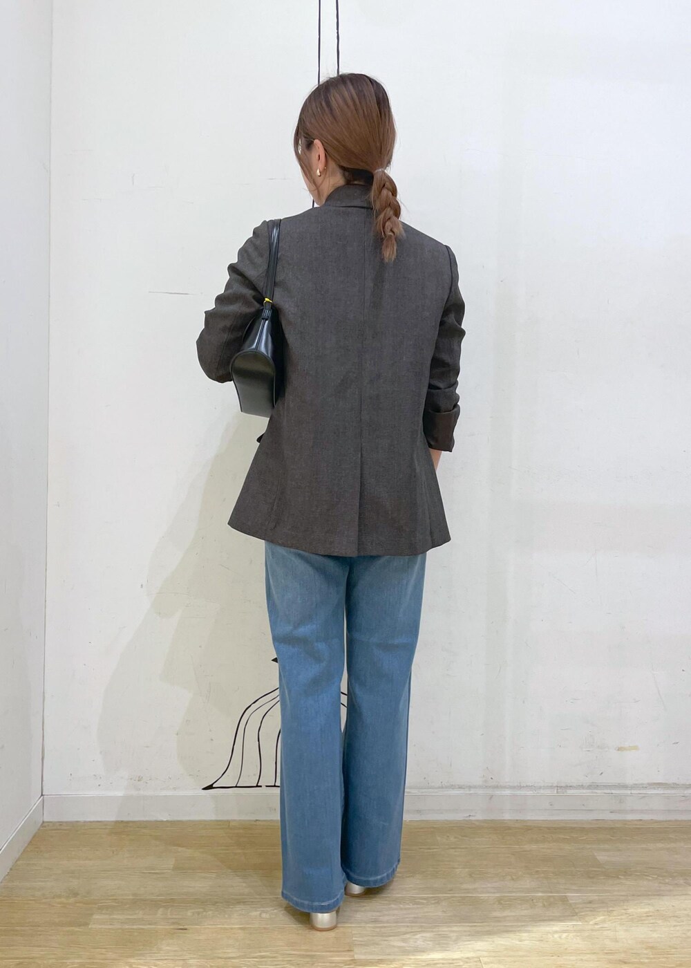 シルバー系のパンプス、ブルー系のデニムパンツ、ブラウン系のテーラードジャケットを着用したレディースの秋コーディネートの2枚目の写真