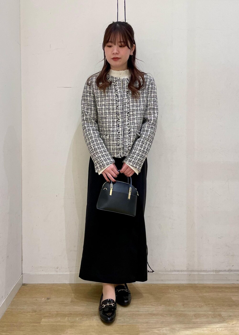 ブラック系のスカート、ホワイト系のシャツ/ブラウス、ブラック系のショルダーバッグを着用したレディースの冬コーディネートの6枚目の写真