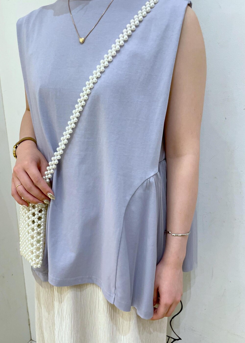 ベージュ系のスカート、ブルー系のTシャツ/カットソー、ホワイト系のサンダルを着用したレディースの夏コーディネートの5枚目の写真