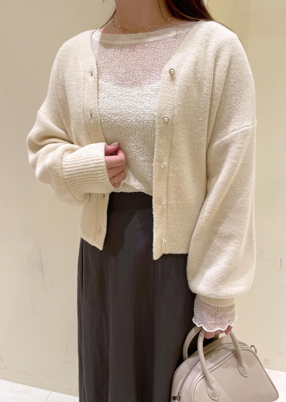 グレー系のスカート、ホワイト系のカーディガン/ボレロ、ホワイト系のTシャツ/カットソーを着用したレディースの秋コーディネートの5枚目の写真
