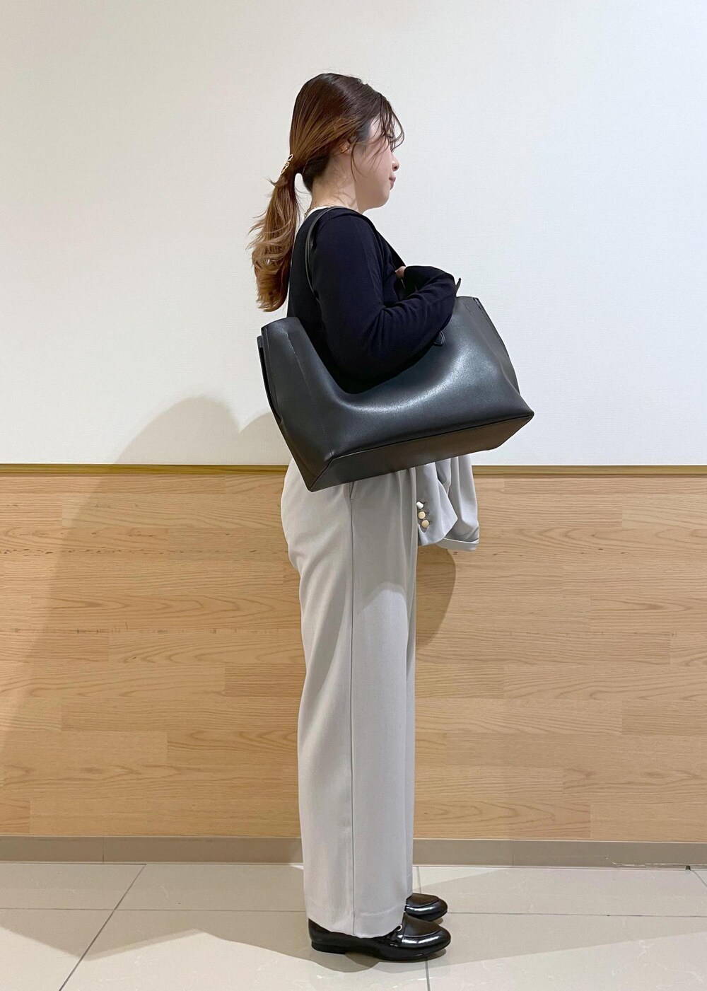 ブラック系のトートバッグ、ブラック系のパンプス、ブルー系のカーディガン/ボレロを着用したレディースの春コーディネートの9枚目の写真