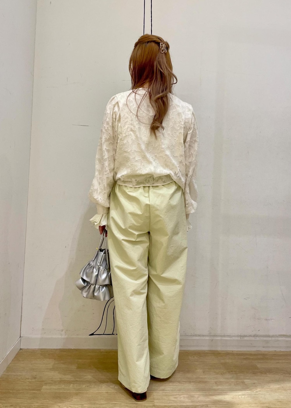 シルバー系のショルダーバッグ、ホワイト系のパンプス、イエロー系のその他パンツを着用したレディースの春コーディネートの2枚目の写真