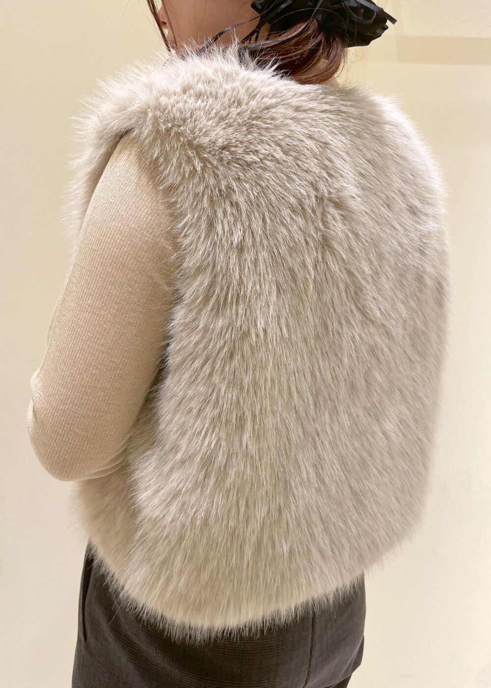 ブラック系のスラックス、ベージュ系のTシャツ/カットソー、ベージュ系のベストを着用したレディースの秋コーディネートの7枚目の写真