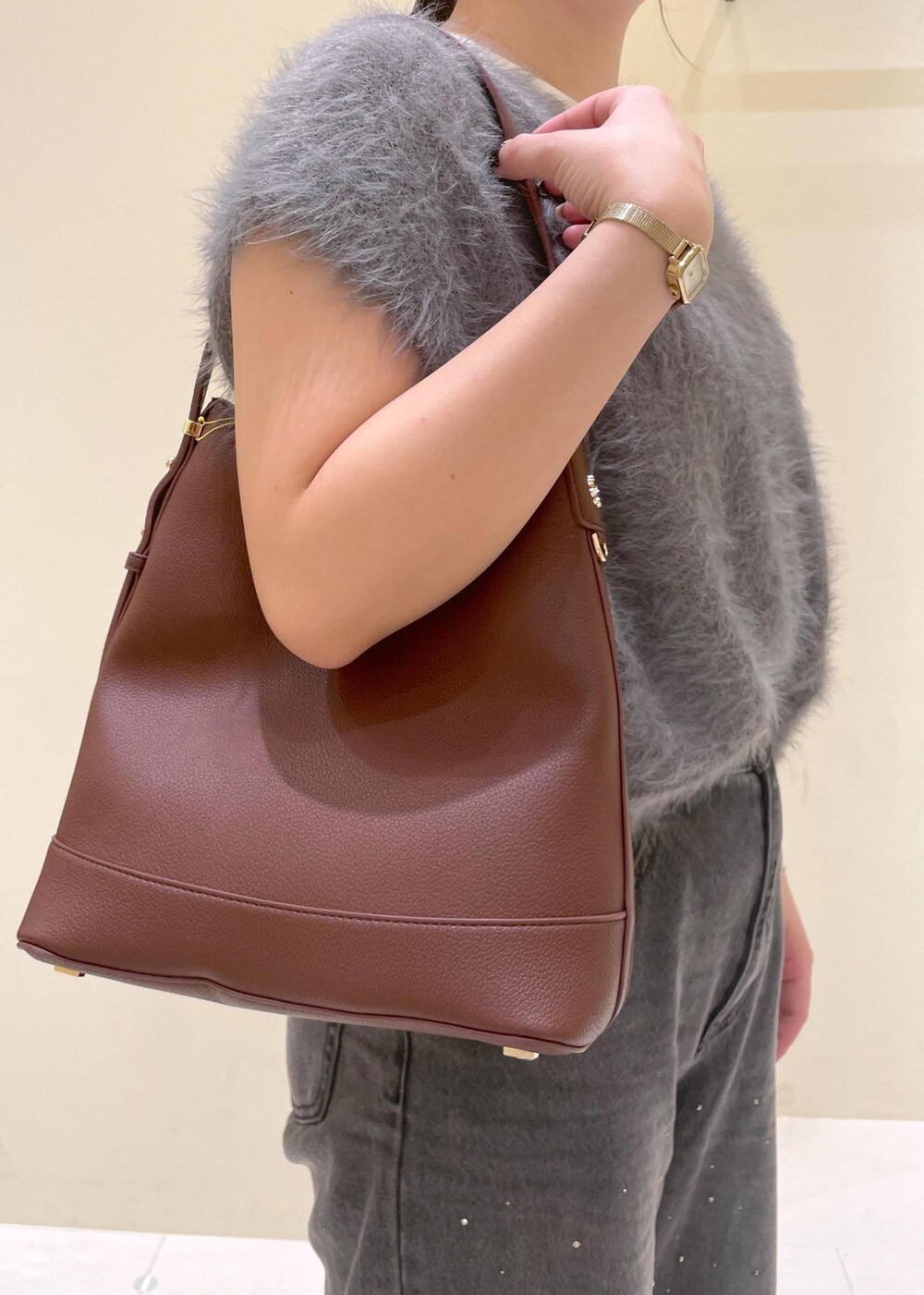 ホワイト系のタンクトップ、グレー系のベスト、ブラック系のブーツを着用したレディースの秋コーディネートの5枚目の写真