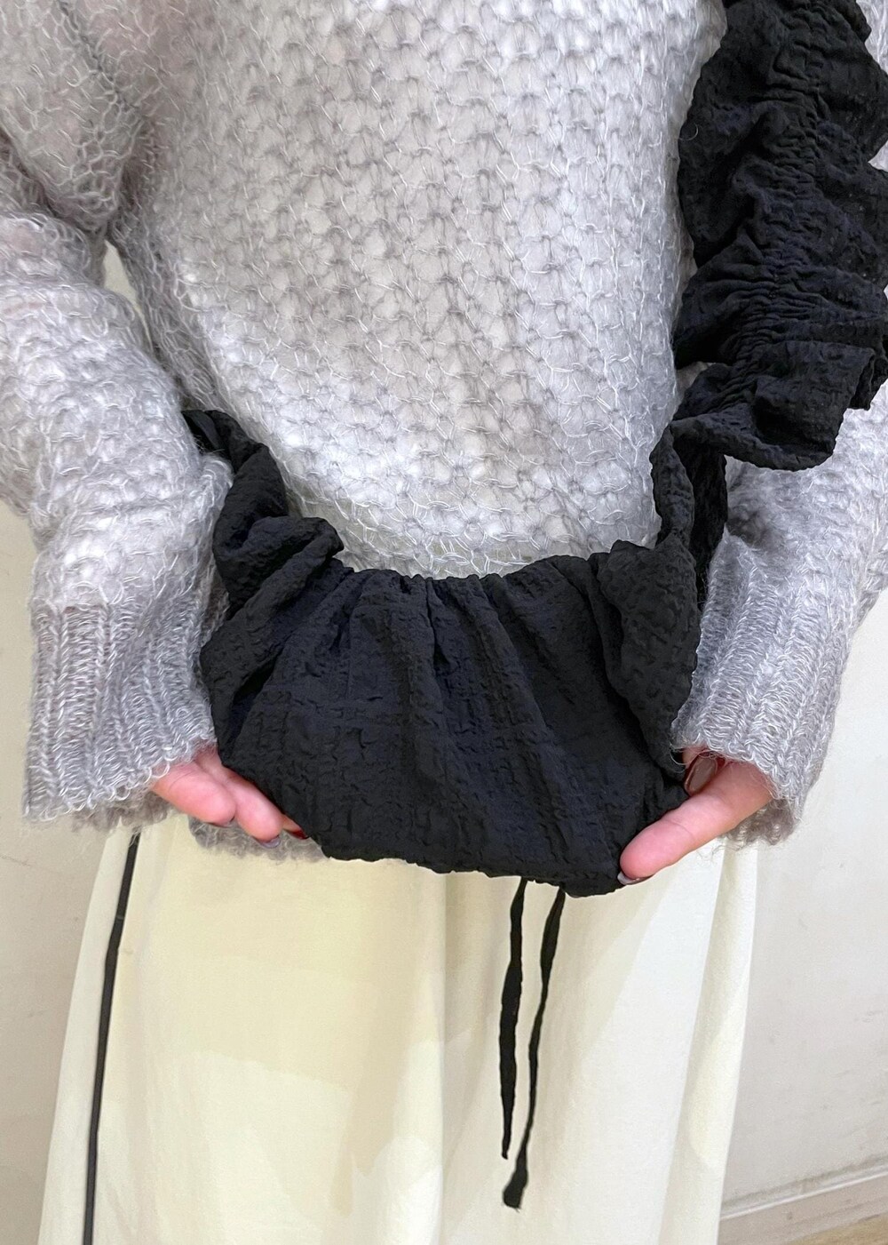 ブラック系のローファー、ホワイト系のスカート、グレー系のニット/セーターを着用したレディースの秋コーディネートの9枚目の写真