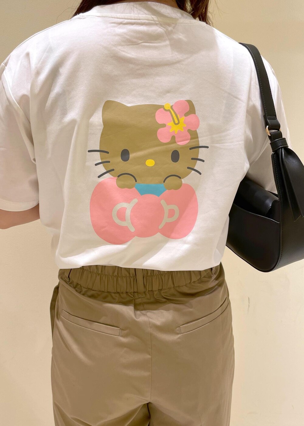 ベージュ系のチノパンツ、ブラウン系のサンダル、ブラック系のハンドバッグを着用したレディースの夏コーディネートの6枚目の写真