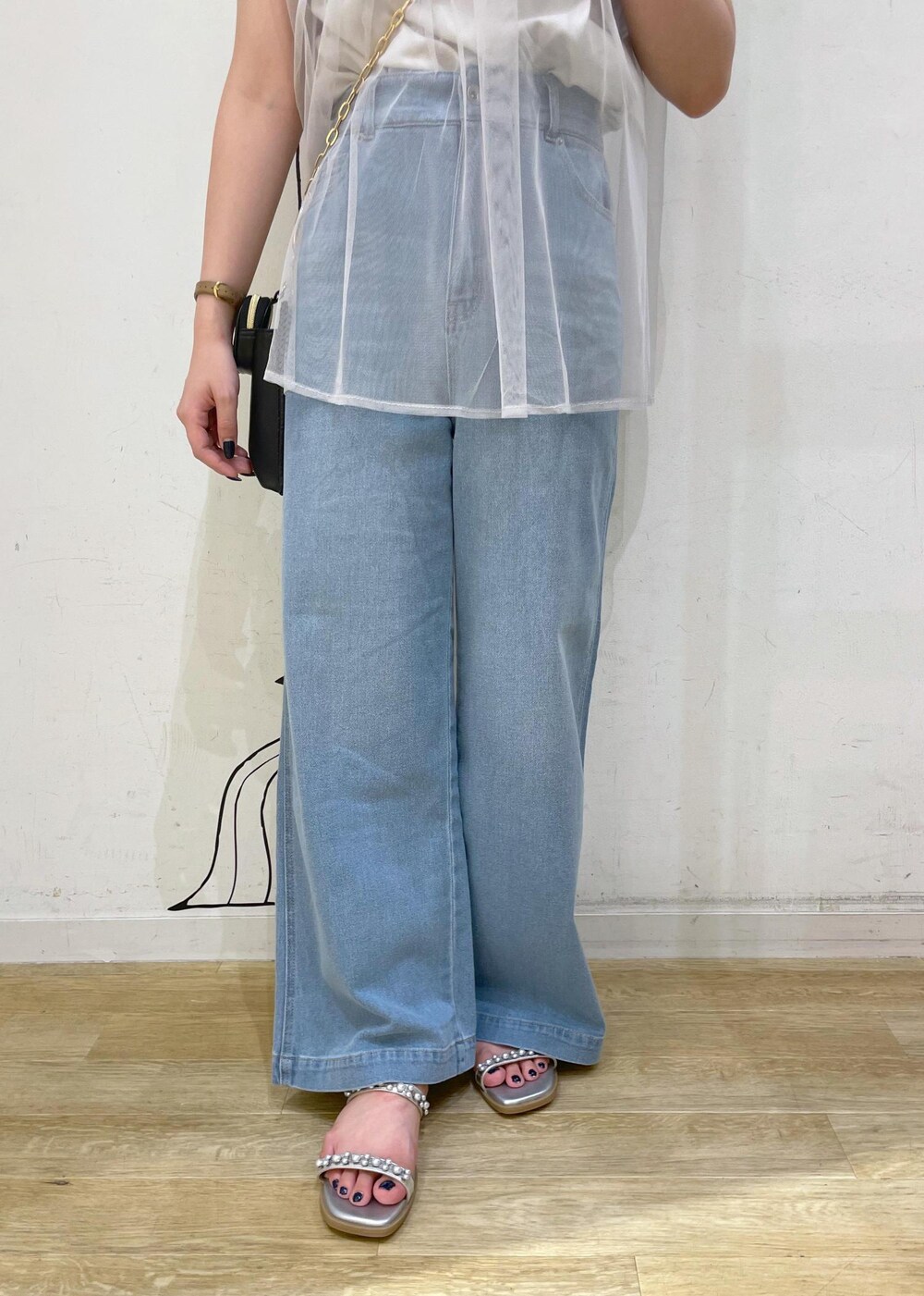 ブルー系のデニムパンツ、シルバー系のサンダル、グレー系のTシャツ/カットソーを着用したレディースの夏コーディネートの6枚目の写真
