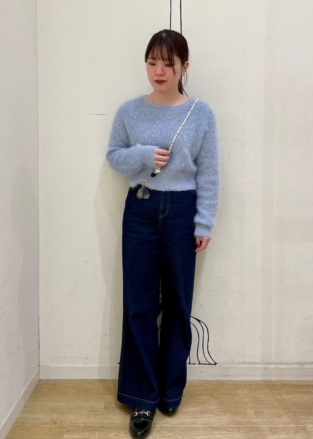 ブラック系のローファー、ブルー系のニット/セーター、ブルー系のデニムパンツを着用したレディースの冬コーディネートの4枚目の写真
