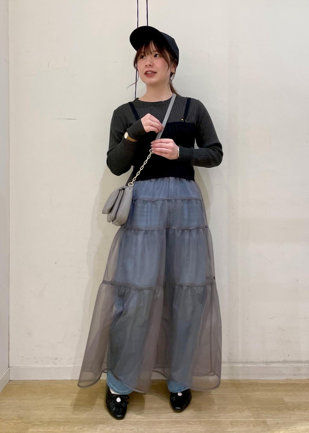 グレー系のショルダーバッグ、ブラック系のベスト、グレー系のニット/セーターを着用したレディースの春コーディネートの9枚目の写真