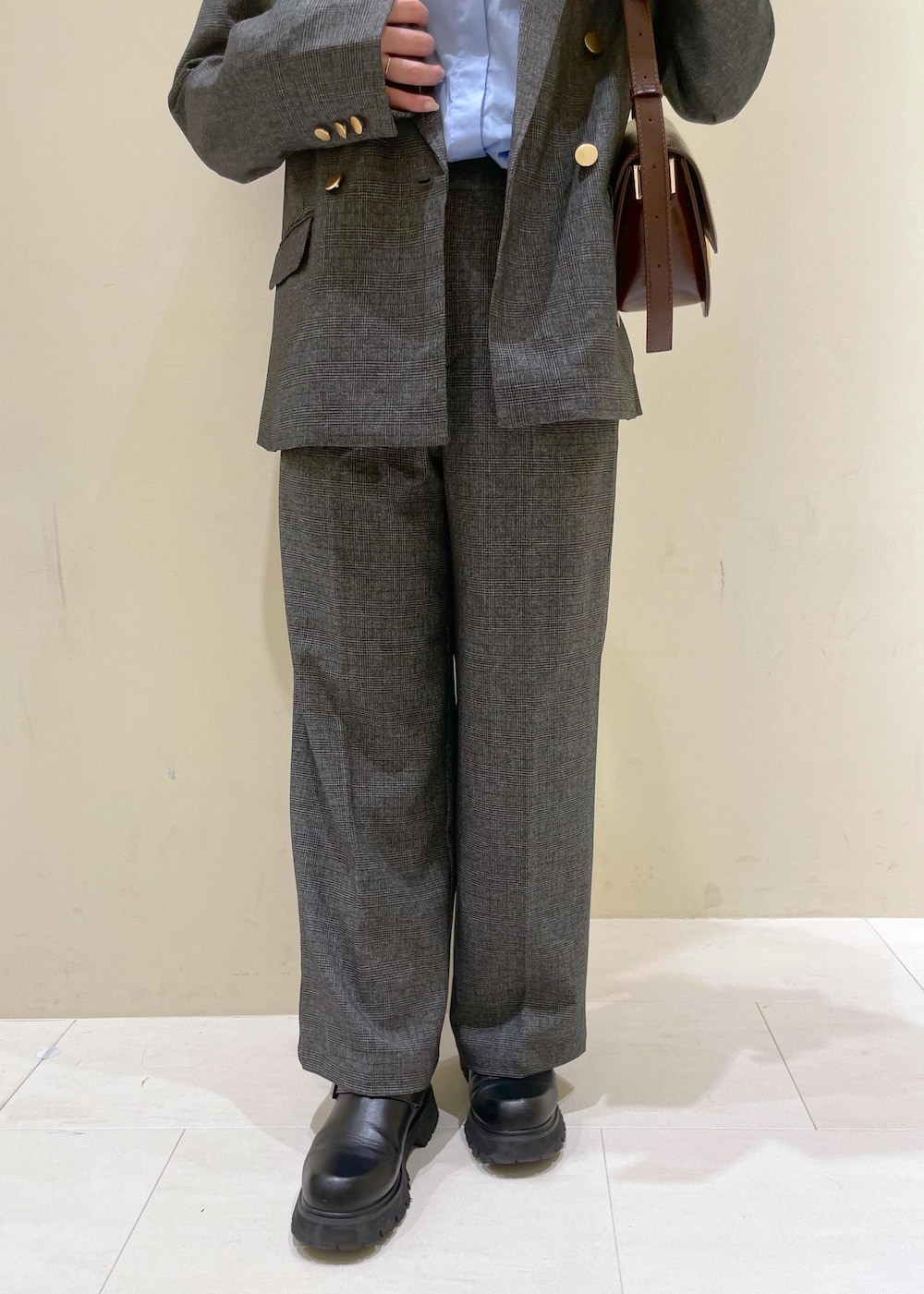 レッド系のショルダーバッグ、グレー系のテーラードジャケット、グレー系のスラックスを着用したレディースの秋コーディネートの9枚目の写真