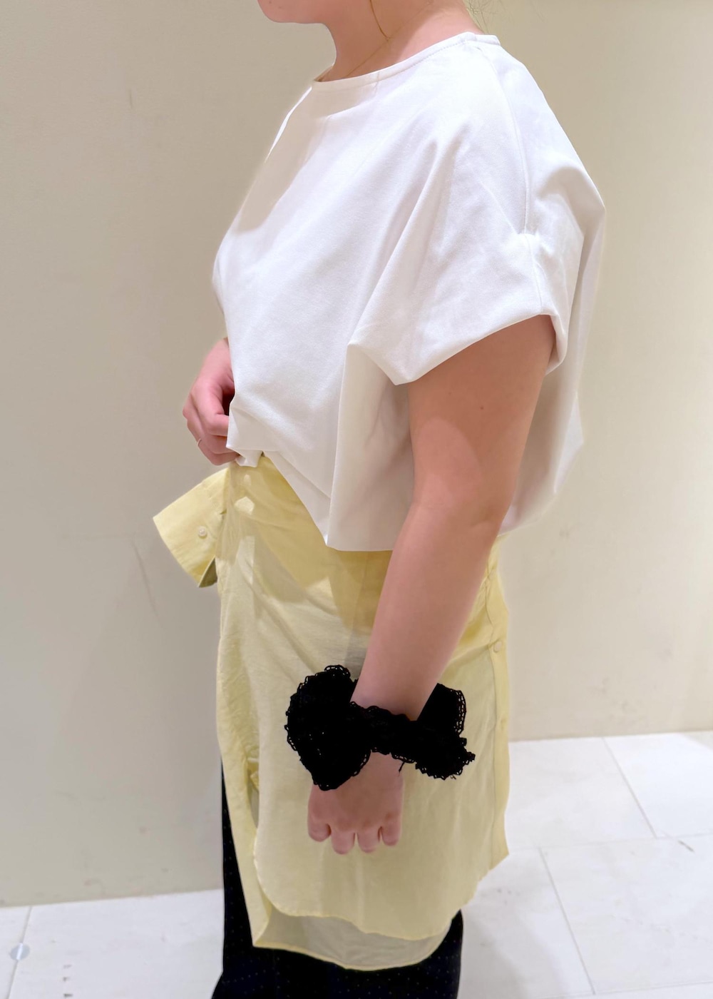 ブラック系のショルダーバッグ、イエロー系のシャツ/ブラウス、ホワイト系のTシャツ/カットソーを着用したレディースの夏コーディネートの7枚目の写真