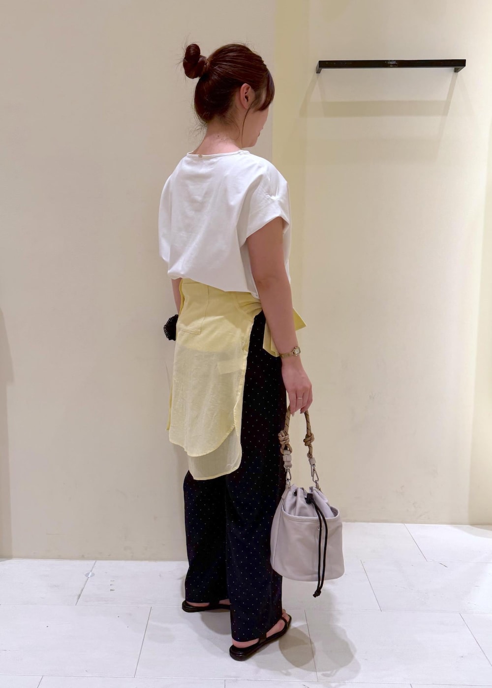 ブラック系のショルダーバッグ、イエロー系のシャツ/ブラウス、ホワイト系のTシャツ/カットソーを着用したレディースの夏コーディネートの5枚目の写真
