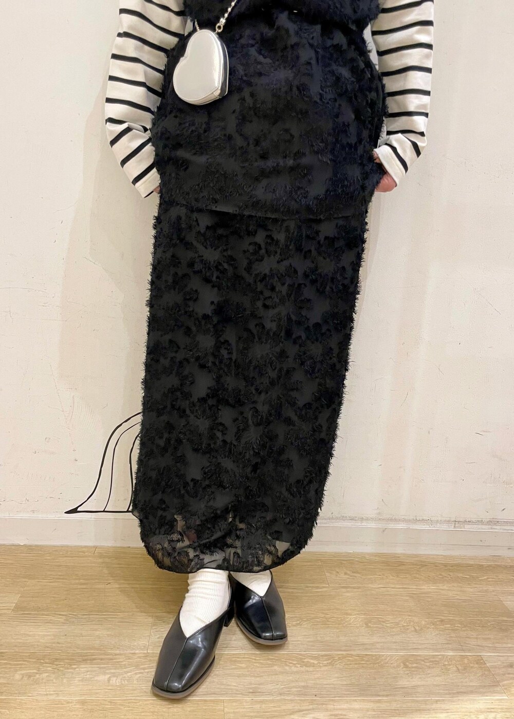 ホワイト系のTシャツ/カットソー、ブラック系のパンプス、ブラック系のスカートを着用したレディースの春コーディネートの3枚目の写真