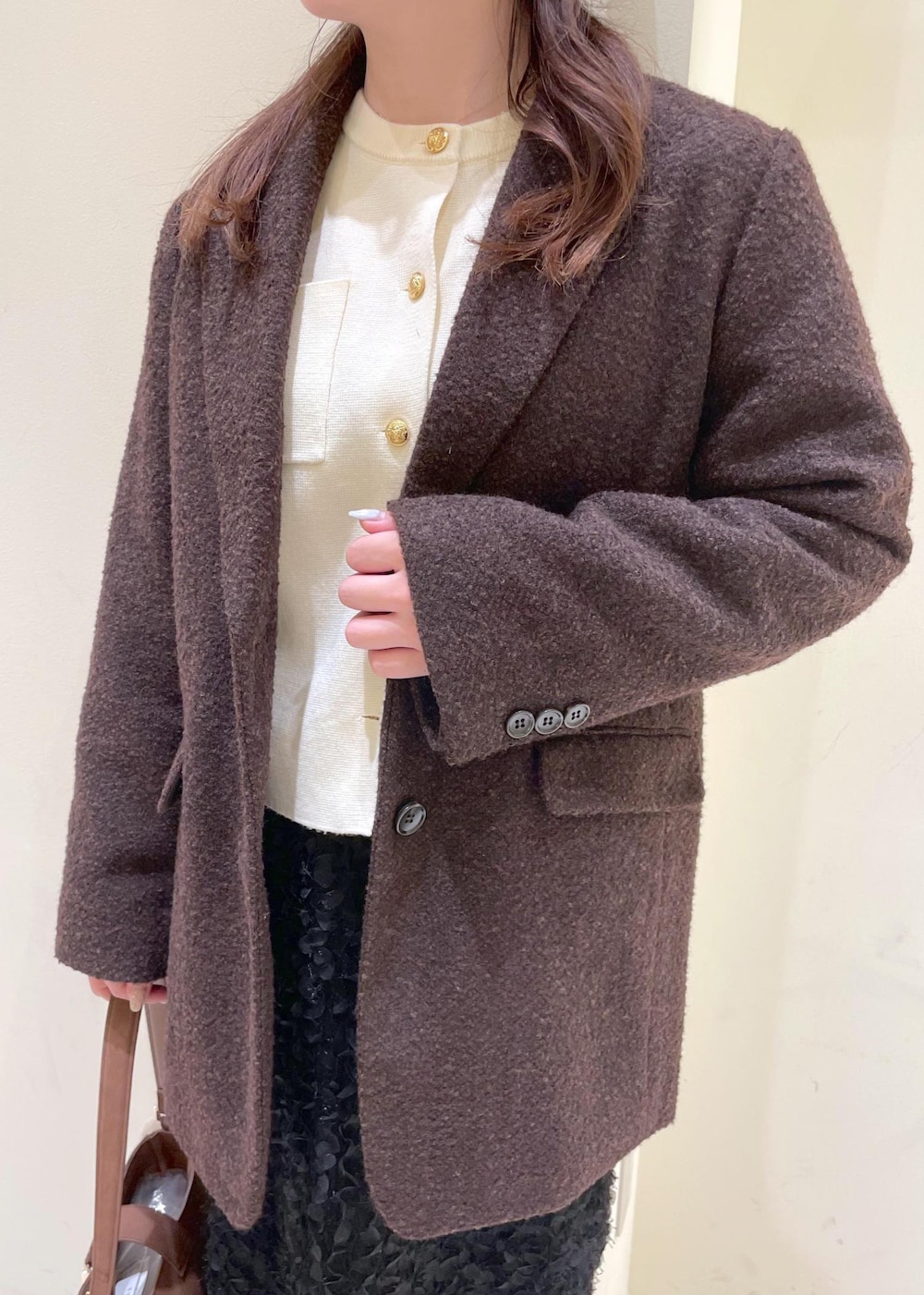 ホワイト系のカーディガン/ボレロ、ブラック系のブーツ、ブラウン系のテーラードジャケットを着用したレディースの秋コーディネートの8枚目の写真