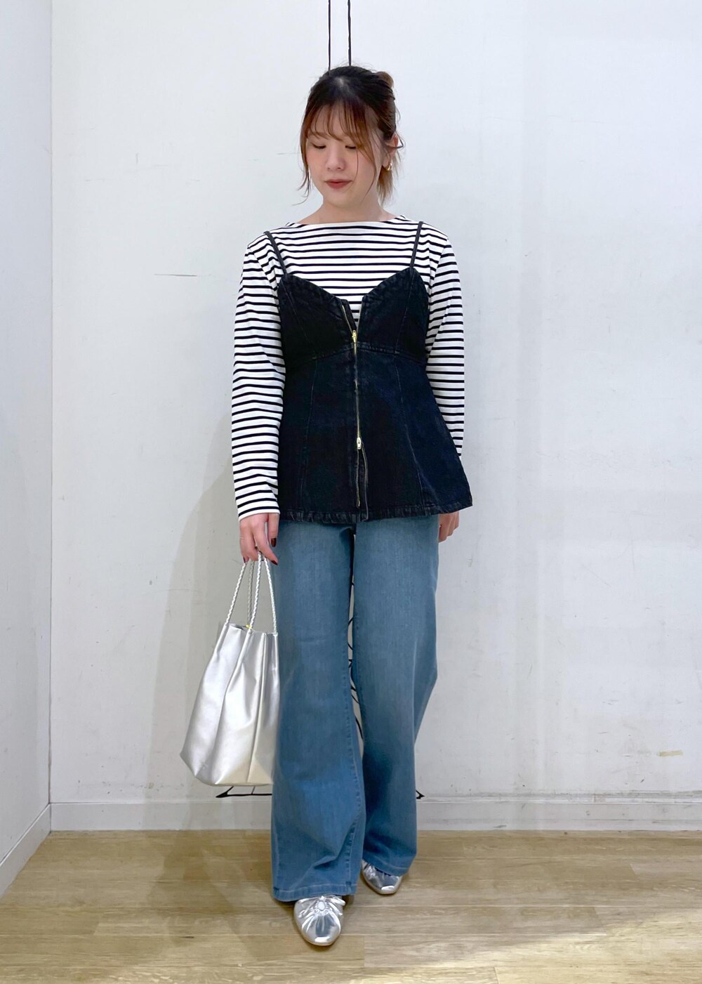 シルバー系のパンプス、ホワイト系のTシャツ/カットソー、ブラック系のベストを着用したレディースの秋コーディネートの4枚目の写真