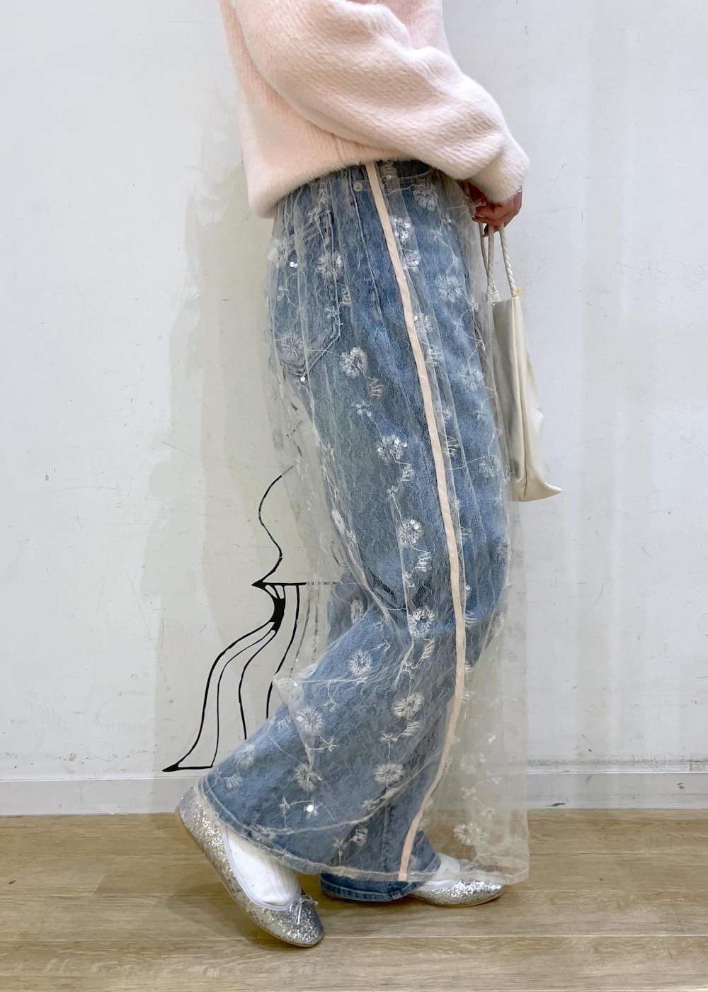 ホワイト系のスカート、シルバー系のバレエシューズ、ブルー系のデニムパンツを着用したレディースの冬コーディネートの7枚目の写真