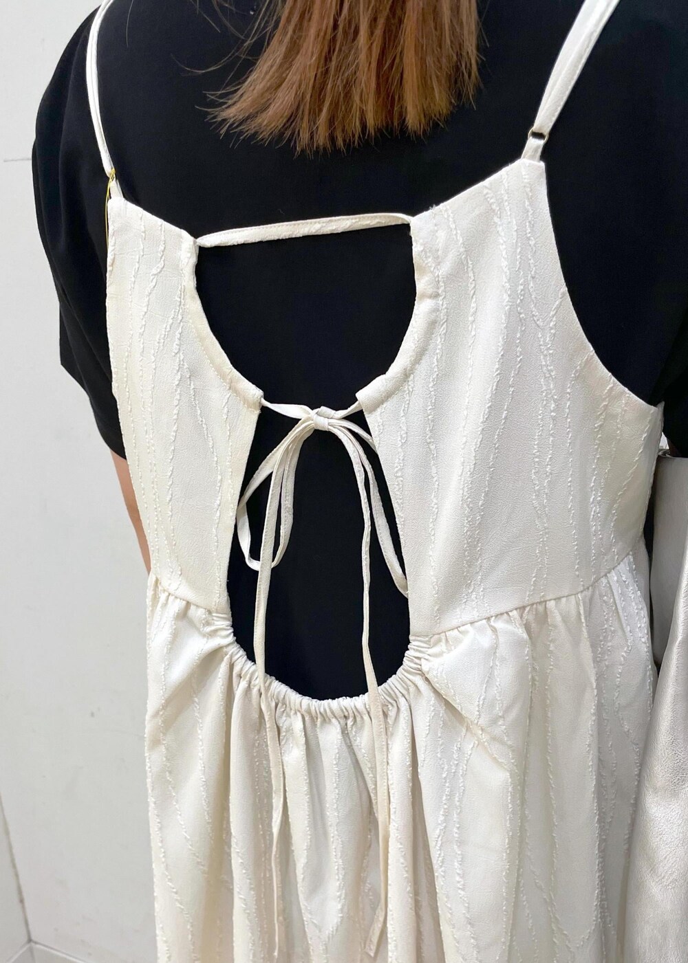 ブラック系のサンダル、ホワイト系のワンピース、ブラック系のTシャツ/カットソーを着用したレディースの夏コーディネートの6枚目の写真