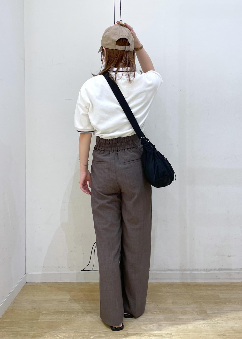 ブラウン系のその他パンツ、ブラック系のサンダル、ホワイト系のポロシャツを着用したレディースの春コーディネートの2枚目の写真