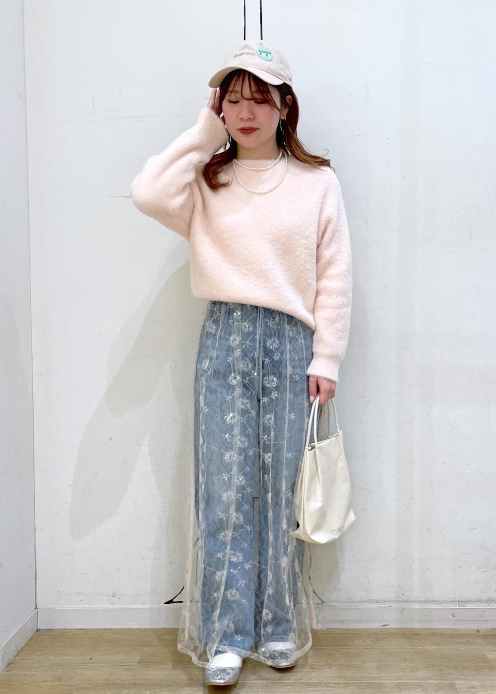 ホワイト系のスカート、シルバー系のバレエシューズ、ブルー系のデニムパンツを着用したレディースの冬コーディネートの4枚目の写真