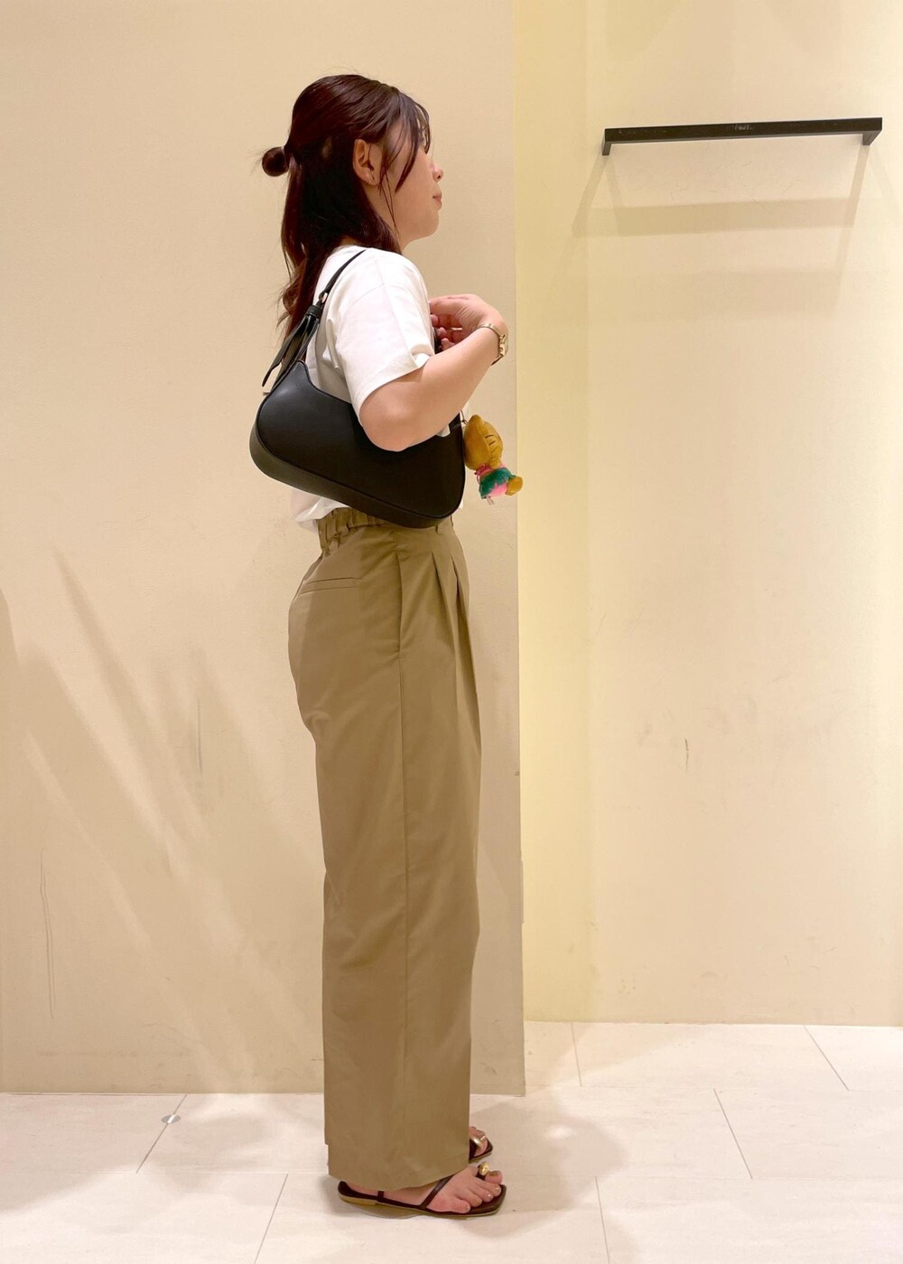 ベージュ系のチノパンツ、ブラウン系のサンダル、ブラック系のハンドバッグを着用したレディースの夏コーディネートの3枚目の写真