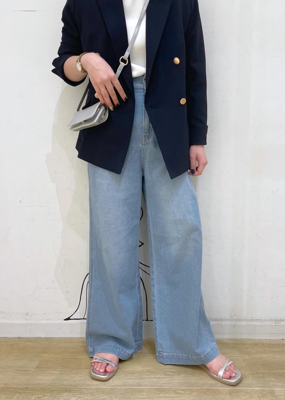 ブルー系のデニムパンツ、シルバー系のサンダル、ホワイト系のニット/セーターを着用したレディースの夏コーディネートの5枚目の写真
