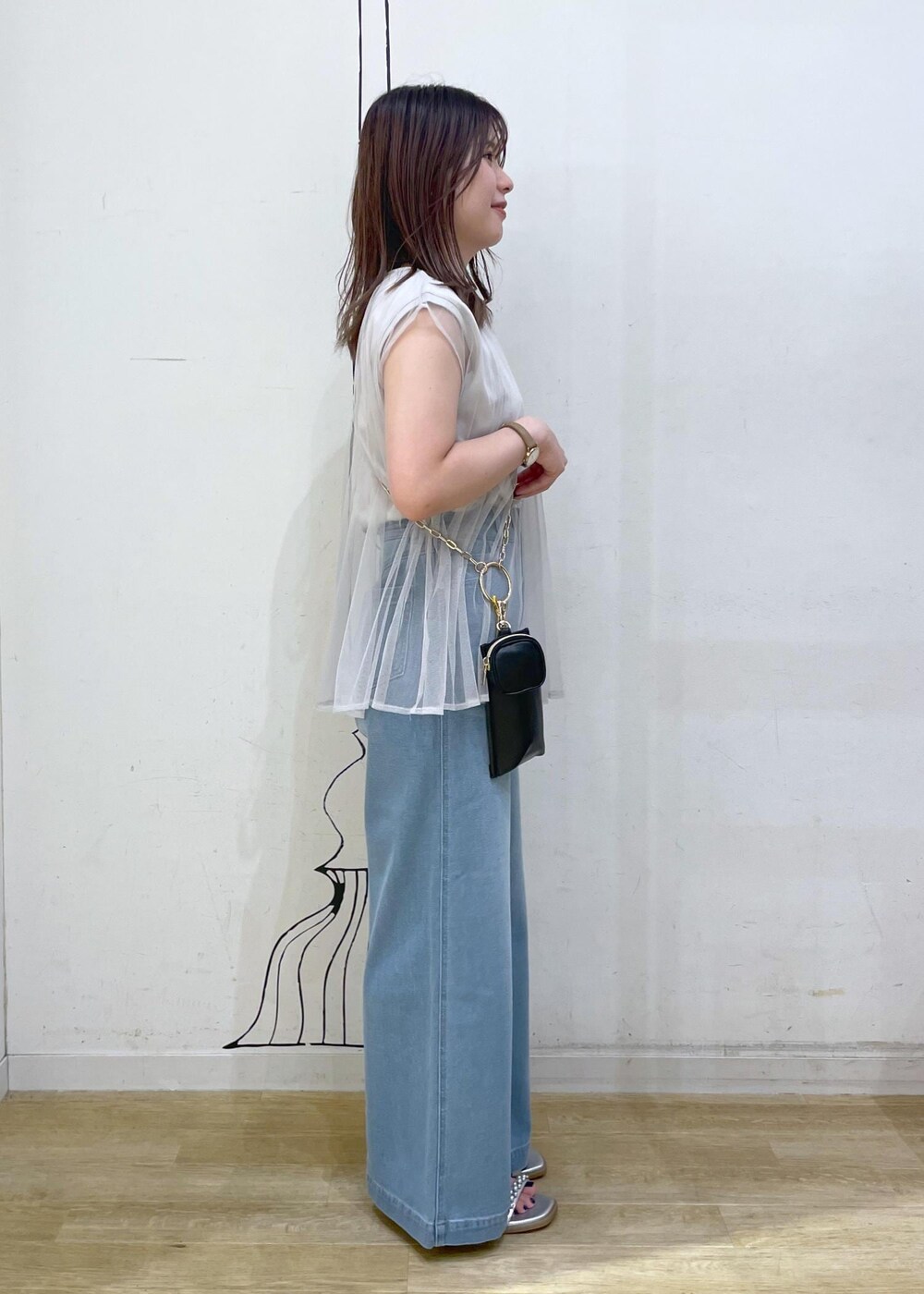 ブルー系のデニムパンツ、シルバー系のサンダル、グレー系のTシャツ/カットソーを着用したレディースの夏コーディネートの3枚目の写真