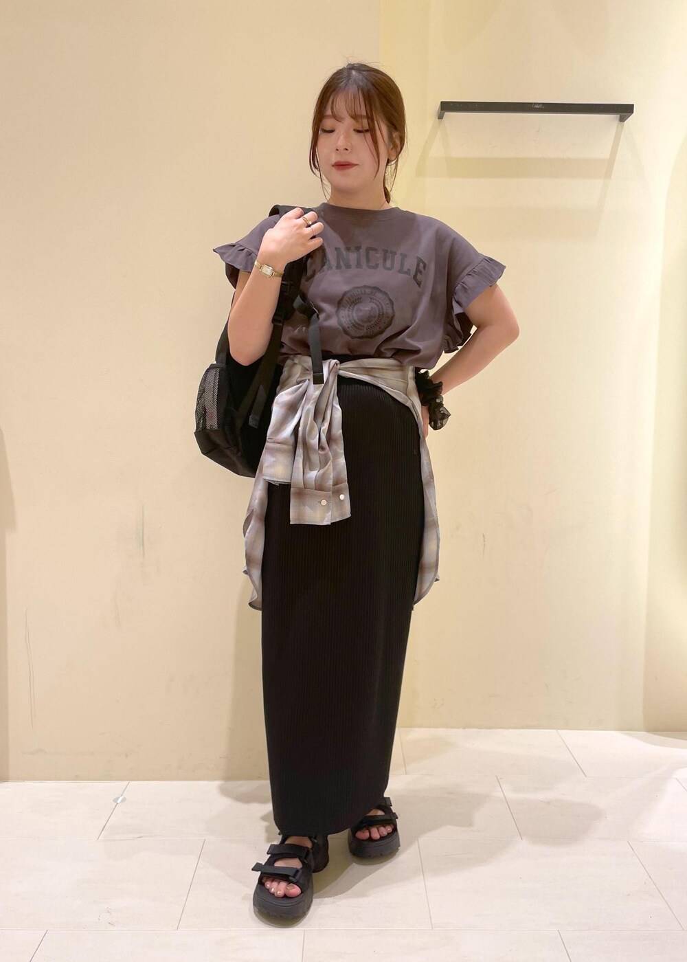 ブラック系のスカート、ブラック系のサンダル、グレー系のTシャツ/カットソーを着用したレディースの夏コーディネートの10枚目の写真